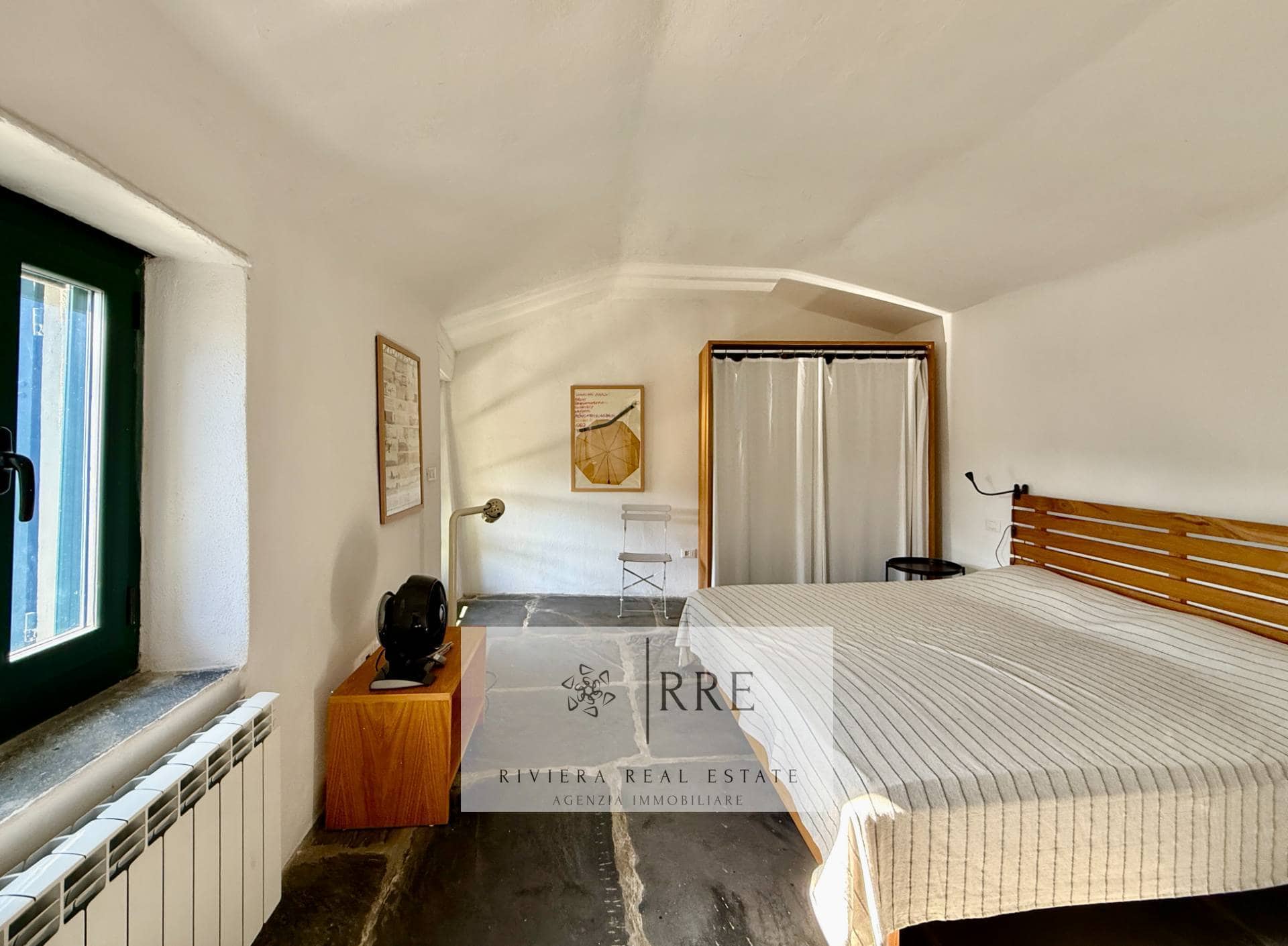 Modern bedroom with minimalist decor and natural light, featuring a large bed, wooden furniture, and.