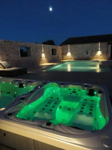 Luxurious hot tub with LED lighting at night in a historic estate in Goudargues, France.