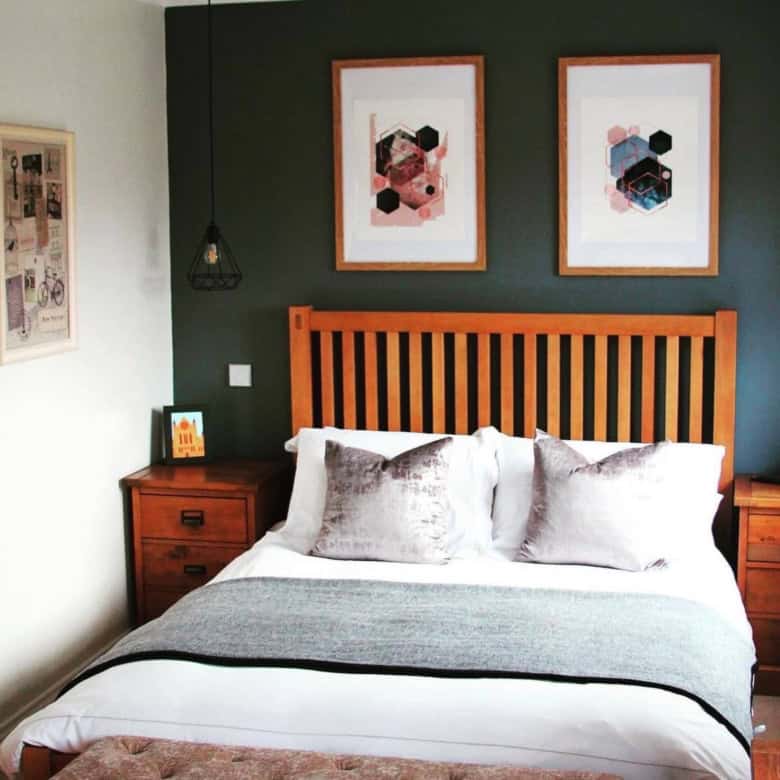 Modern bedroom with wooden bed frame, abstract wall art, and cozy bedding.
