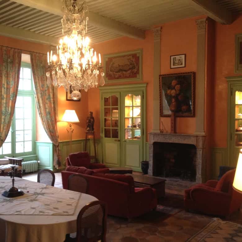 Bright bedroom in Château de la Chassaigne with large window and balcony view.