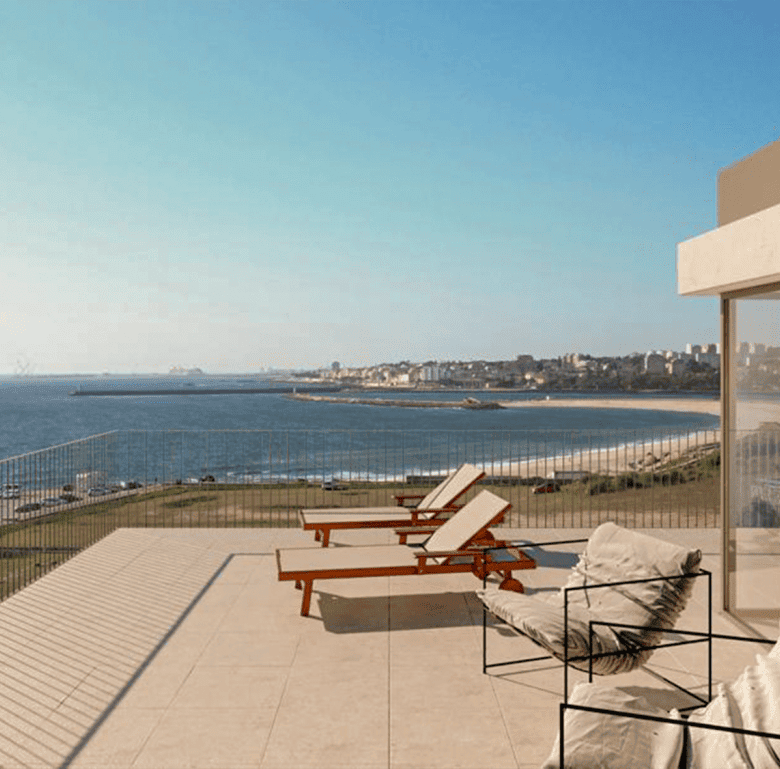 Sea view from a modern terrace in Porto, Portugal, featuring lounge chairs and outdoor seating.