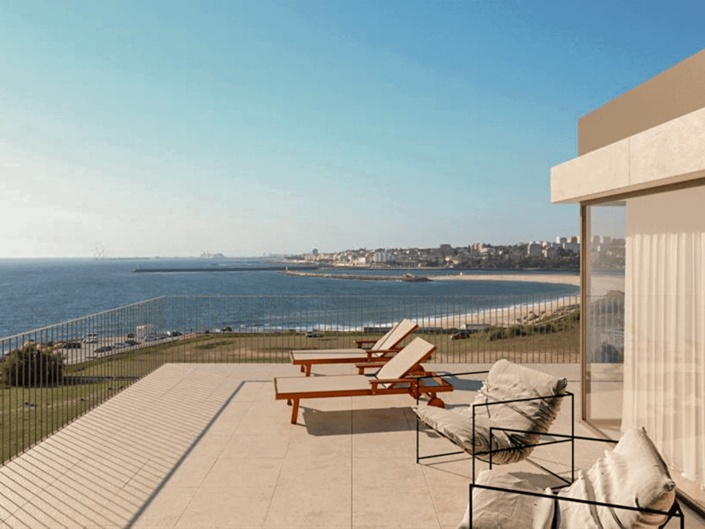 Sea view from a modern terrace in Porto, Portugal, featuring lounge chairs and outdoor seating.