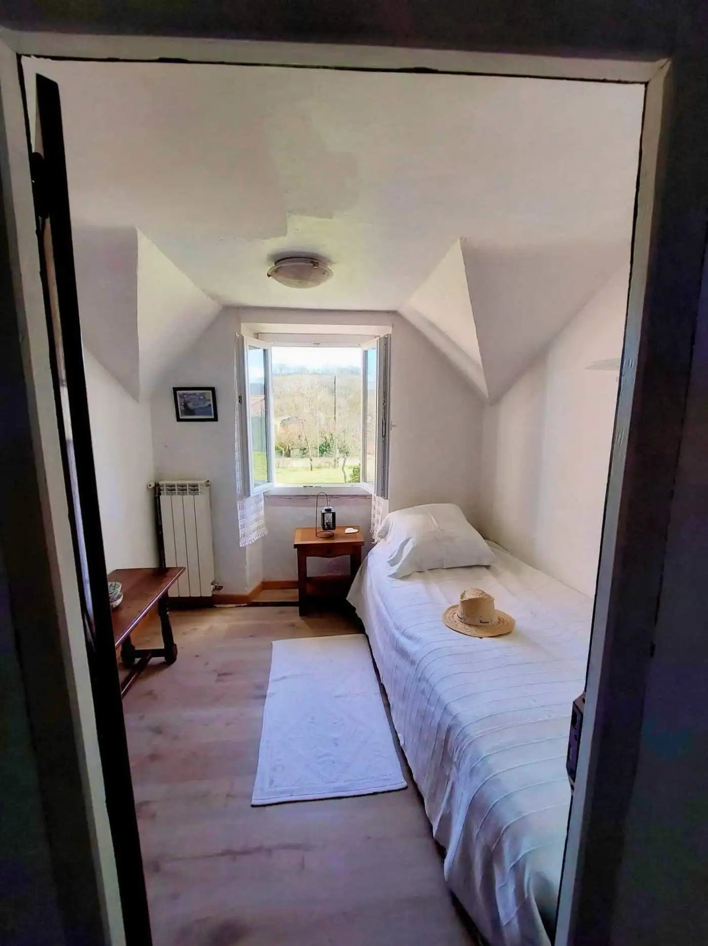 Farmhouse for Sale in Madiran, France Interior view of a cozy farmhouse hallway in Madiran, France, with a door leading to a bright room.