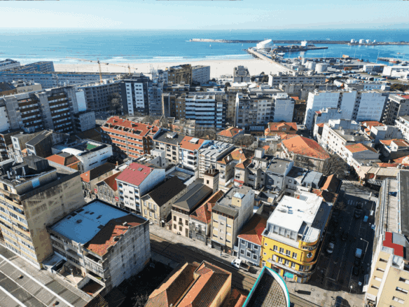 Lighthouse and coastal cityscape in Matosinhos, Portugal, with ocean view and urban buildings.