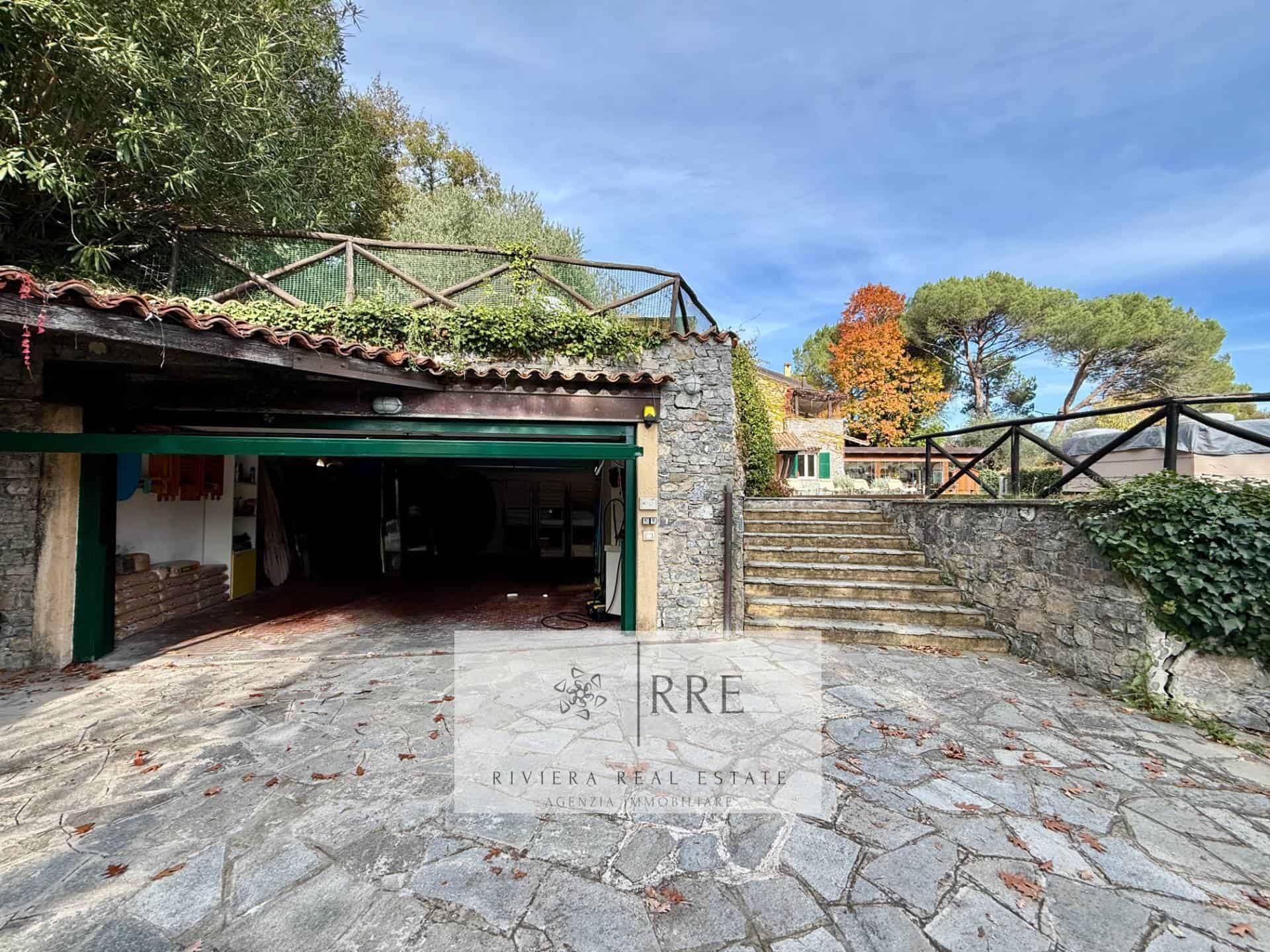 Stone house with garden and outdoor stairs in a scenic setting.