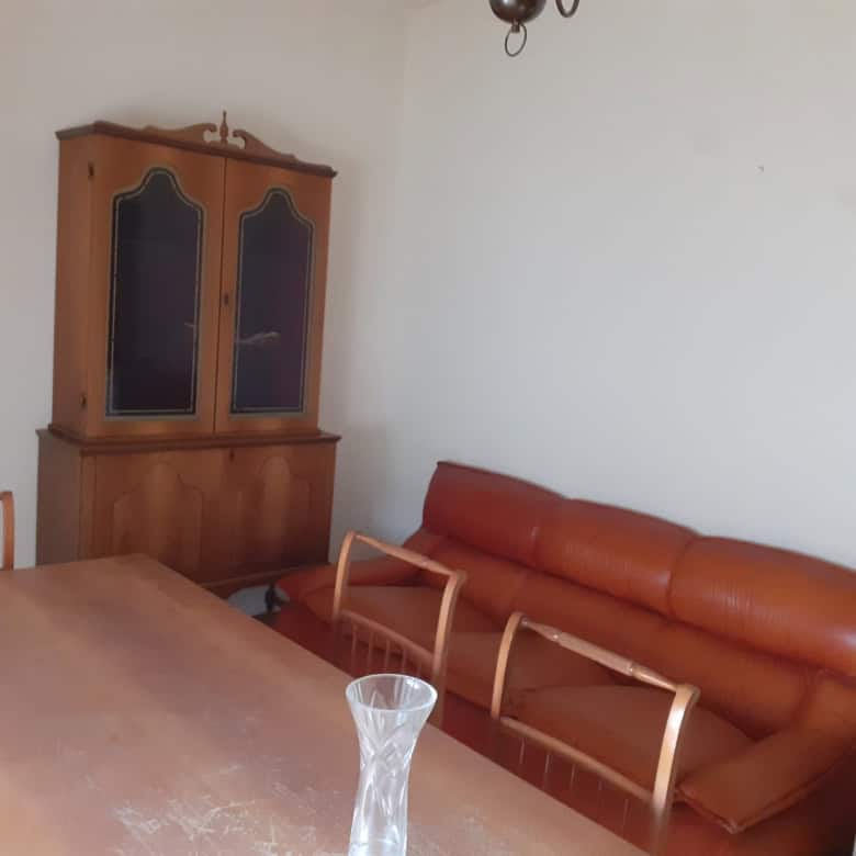 Charming living room with wooden furniture and a leather sofa in a Sardinian apartment. Perfect for.