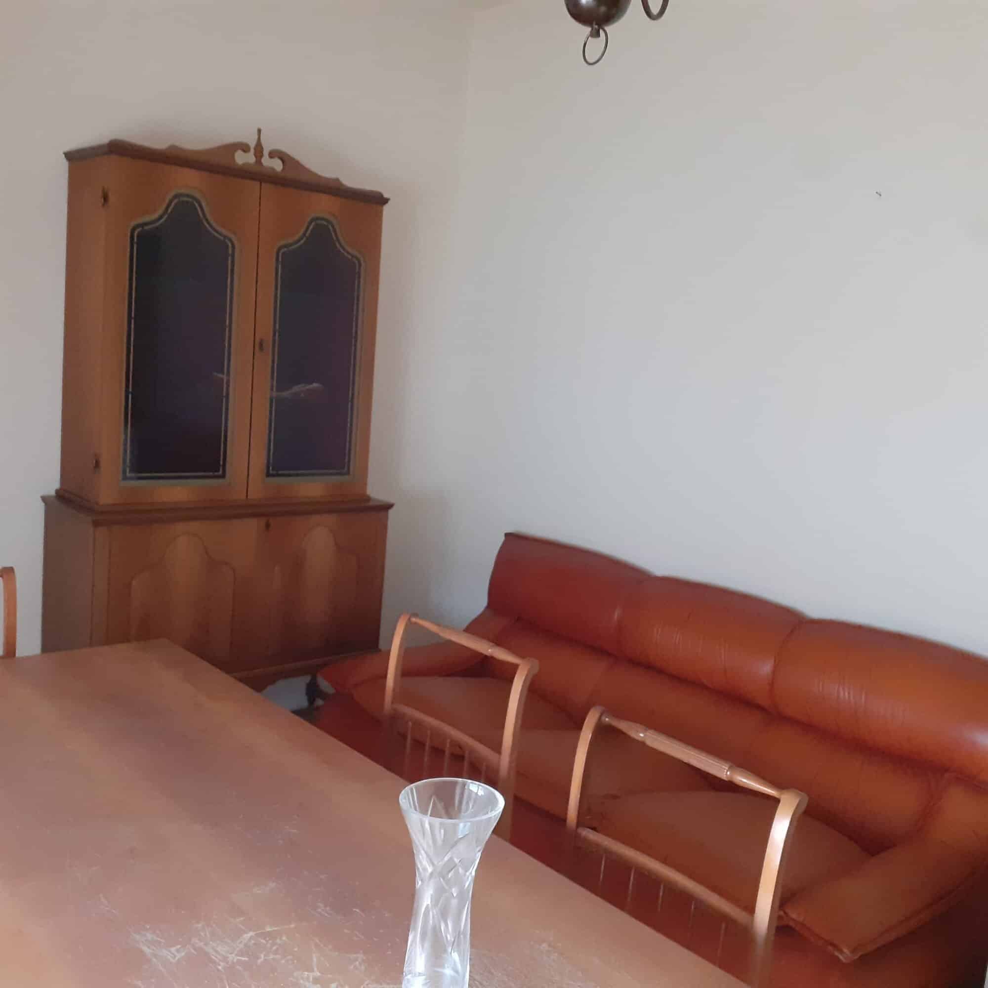 Charming living room with wooden furniture and a leather sofa in a Sardinian apartment. Perfect for.