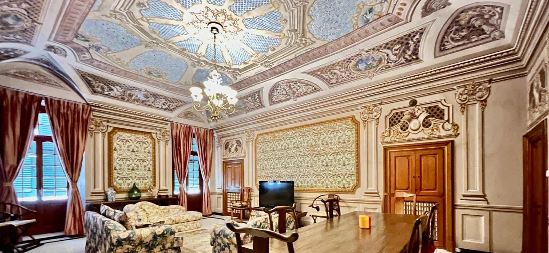 Elegant historic living room with ornate ceiling and classic decor.