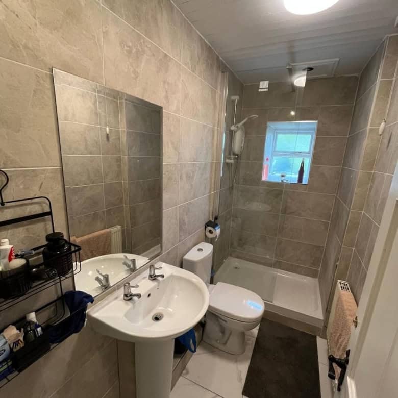 Bright Irish cottage bathroom with modern fixtures and neutral tile decor.