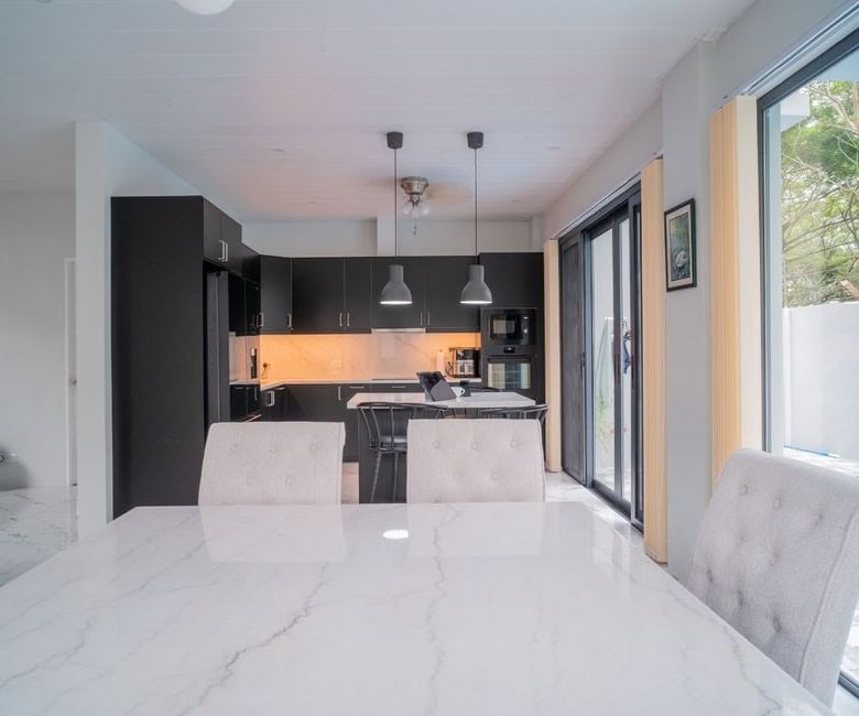 Elegant kitchen with black cabinets and bright lighting.