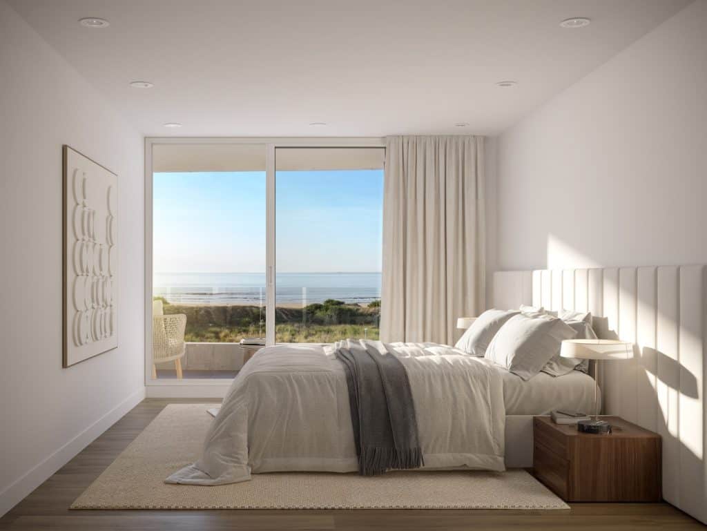 Ocean view bedroom with large window, white decor, and cozy bedding in Casa Rambla.