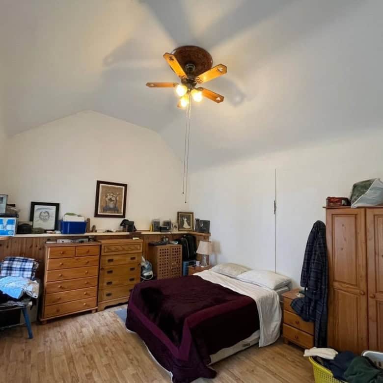 Bright bedroom with wooden furniture and a sloped ceiling in a charming Irish cottage.