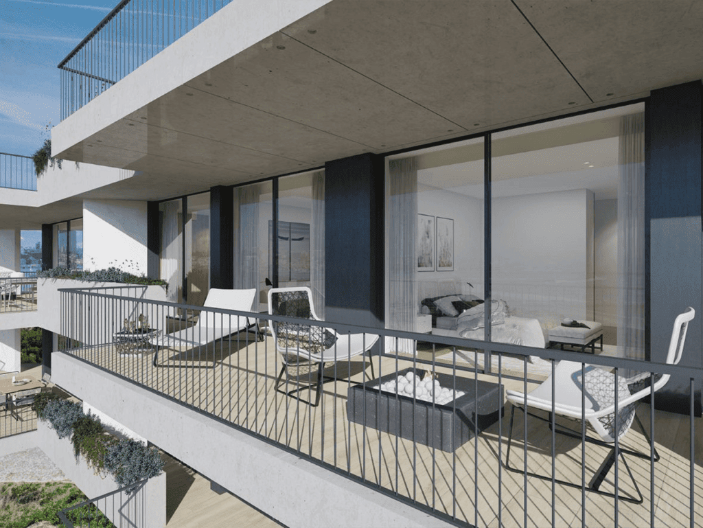 Contemporary balcony overlooking Porto's sea with outdoor seating and glass railing.