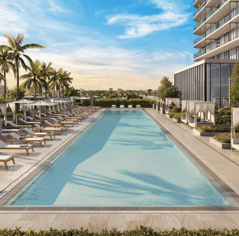 Modern hotel pool with palm trees and sun loungers in North Beach Miami, Florida.
