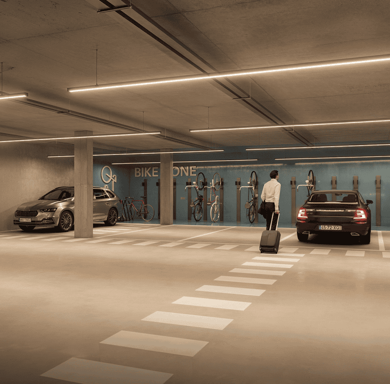 Underground parking facility in Lisbon featuring cars, bicycles, and modern lighting.