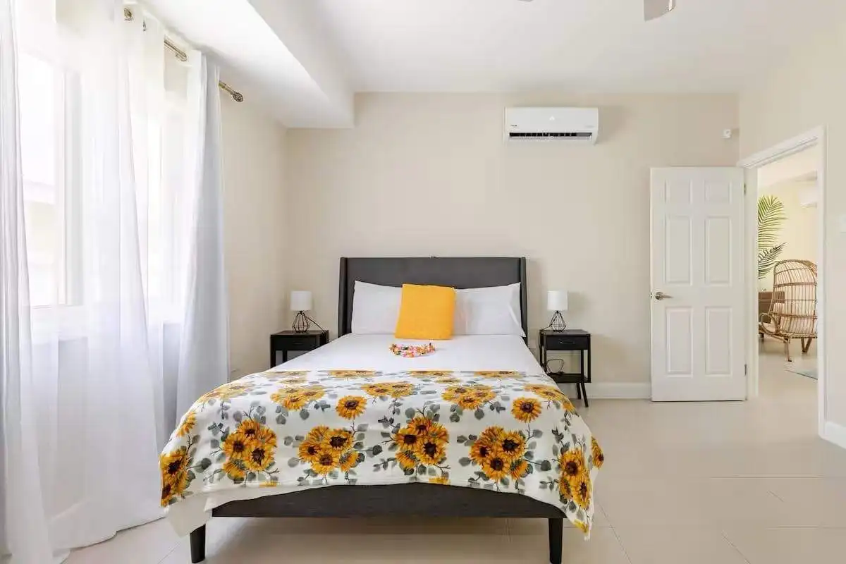 Luxury 3 Bed House in Jamaica Modern bedroom with sunflower bedding in a bright, airy Jamaican home.