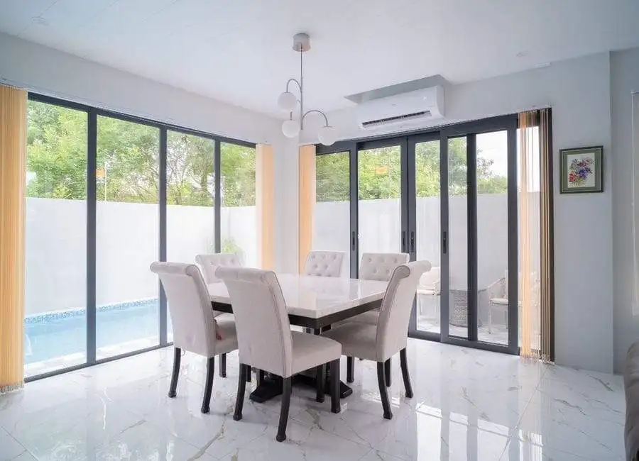 Luxury Villa Dining Area in The Orchard Golf Club Elegant dining room with large glass doors overlooking the pool and garden. Perfect for family meals.