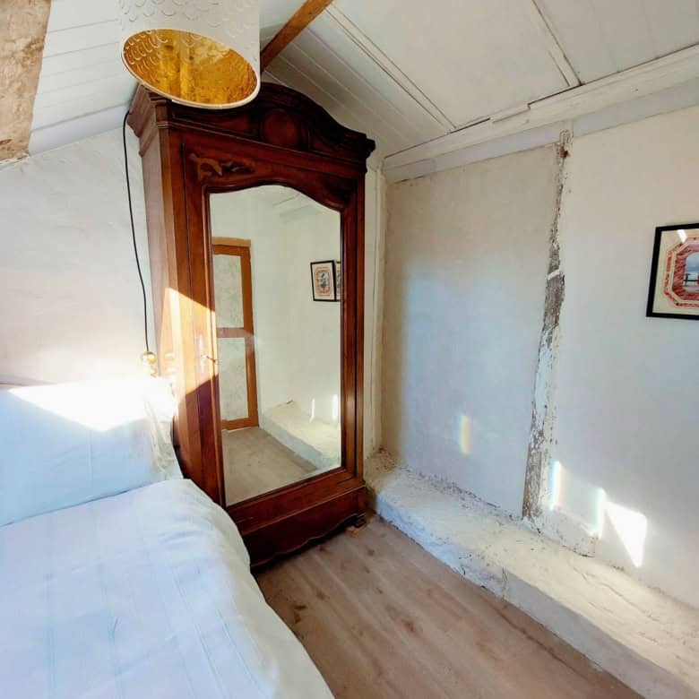 Beautiful bedroom with floral bedding in a traditional French farmhouse setting.