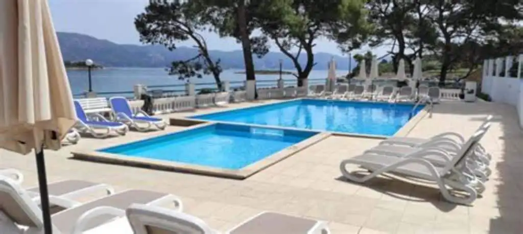 Luxury 2 Bed Apartment Pool View Poolside view of a luxury 2-bedroom apartment in Lumbarda Resort, Korčula, Croatia.