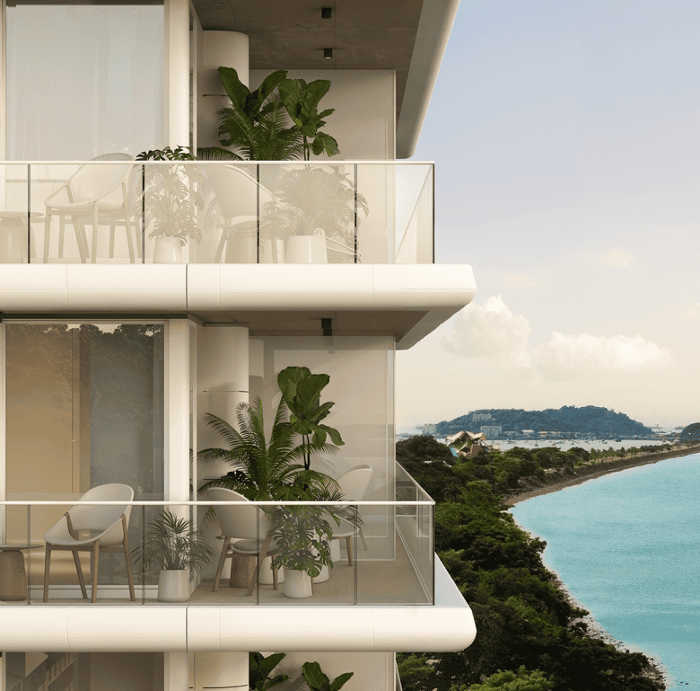 Balcony view of Nautilus residential building in Panama City with lush greenery and ocean backdrop.