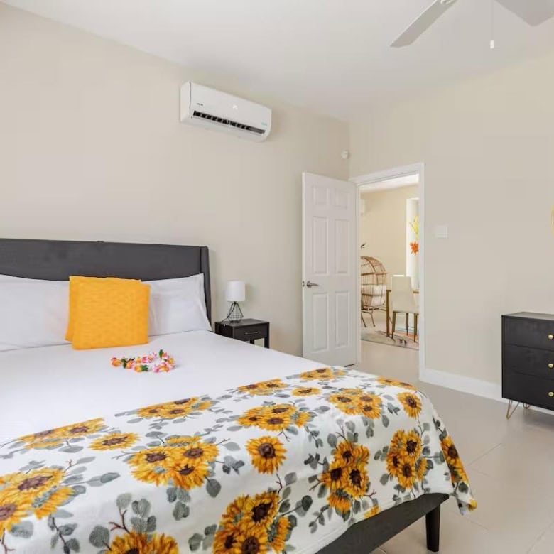 Spacious bedroom with sunflower-themed bedding in a modern Jamaican home.