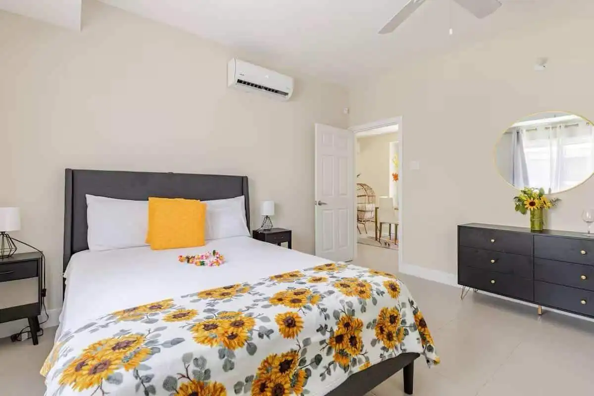 Luxury 3 Bed House for Sale in Sunshine Seashore Spacious bedroom with sunflower-themed bedding in a modern Jamaican home.