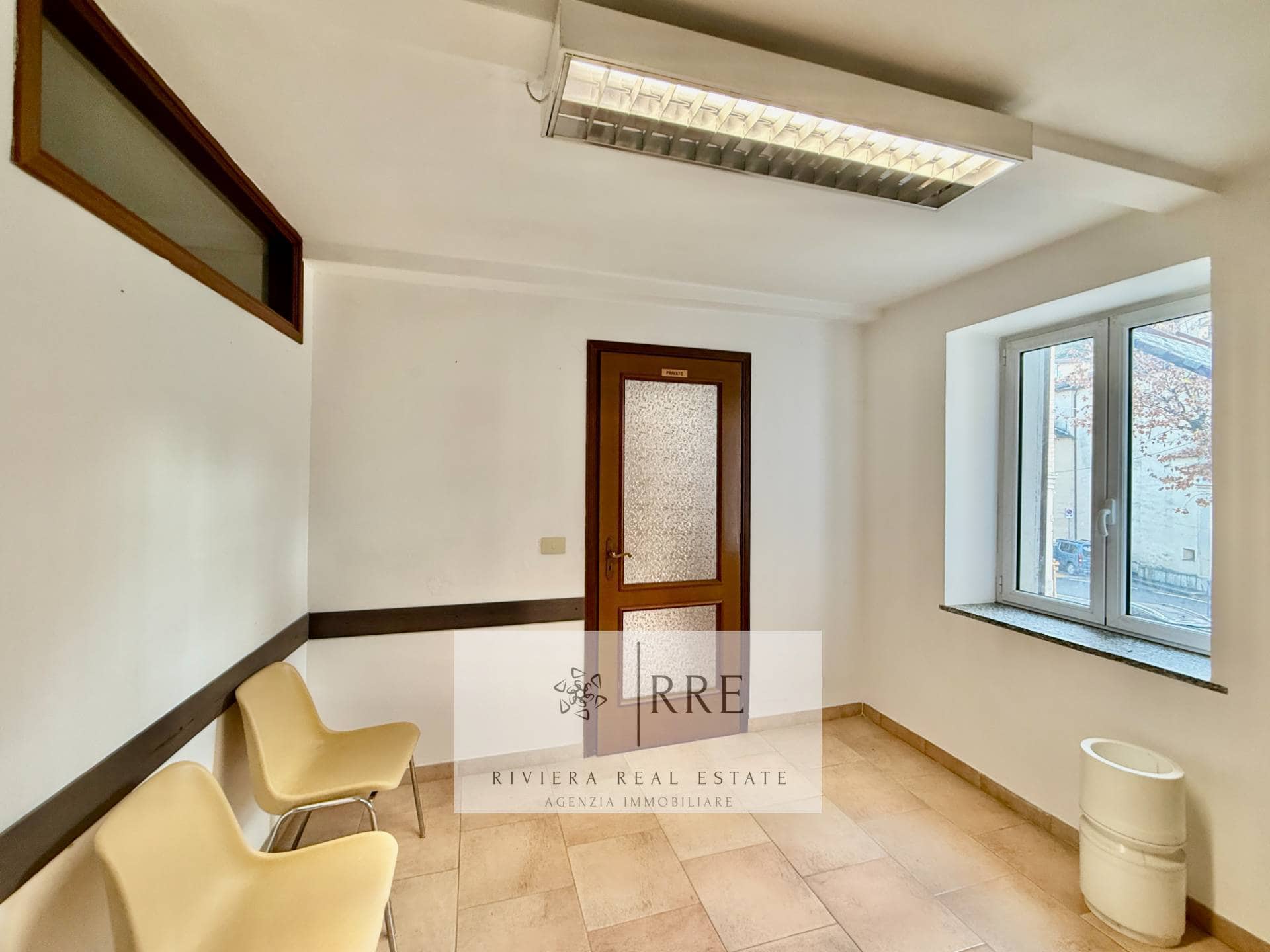 Office interior with bright natural light, white walls, and minimalist decor. Comfortable seating an.