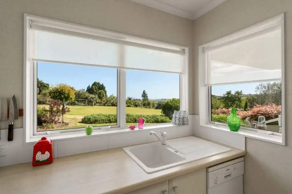 Charming Cottage Kitchen with Scenic Views Bright kitchen with large windows overlooking lush gardens and scenic landscape in Tauranga, New Zea.