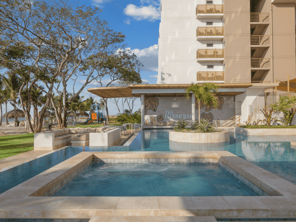 Modern pool area at Surfside Playa Caracol, Panama, with lush landscaping and ocean views.