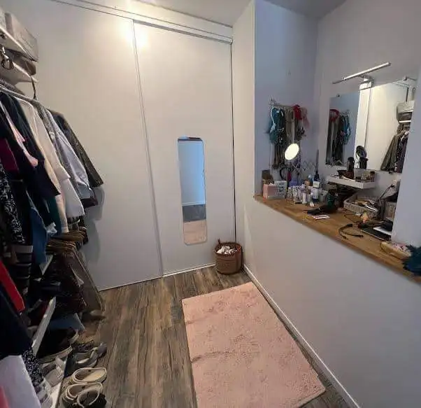 Spacious walk-in closet with a full-length mirror, organized clothing, and shoes for a comfortable d.