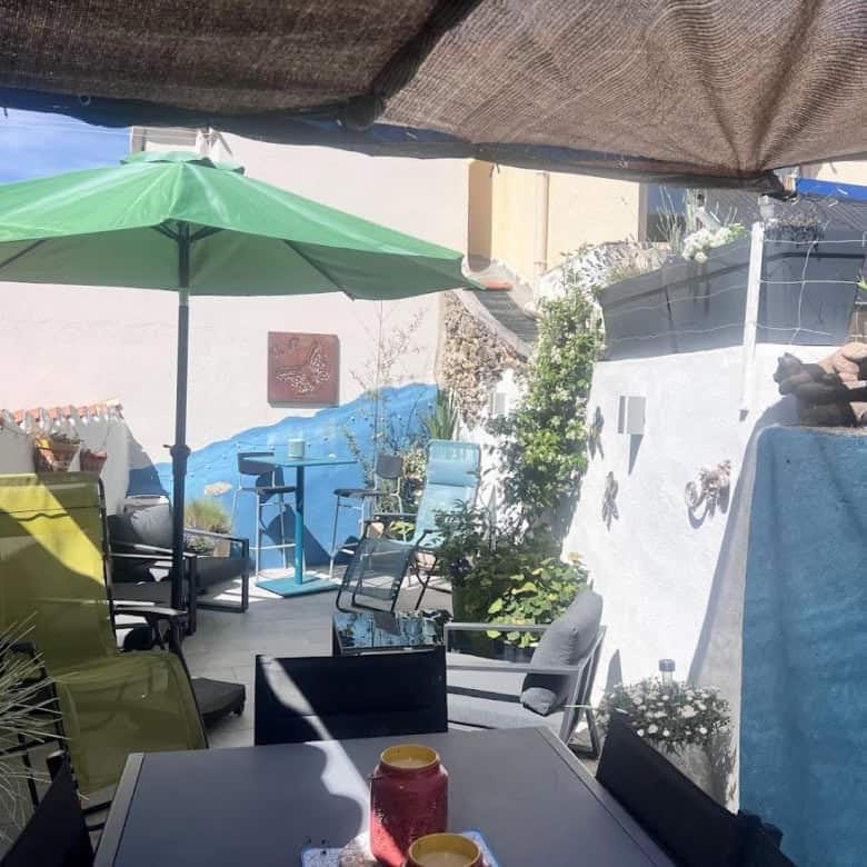 Outdoor terrace with seating and umbrellas in a renovated village house in Ria-Sirach, France. Perfe.