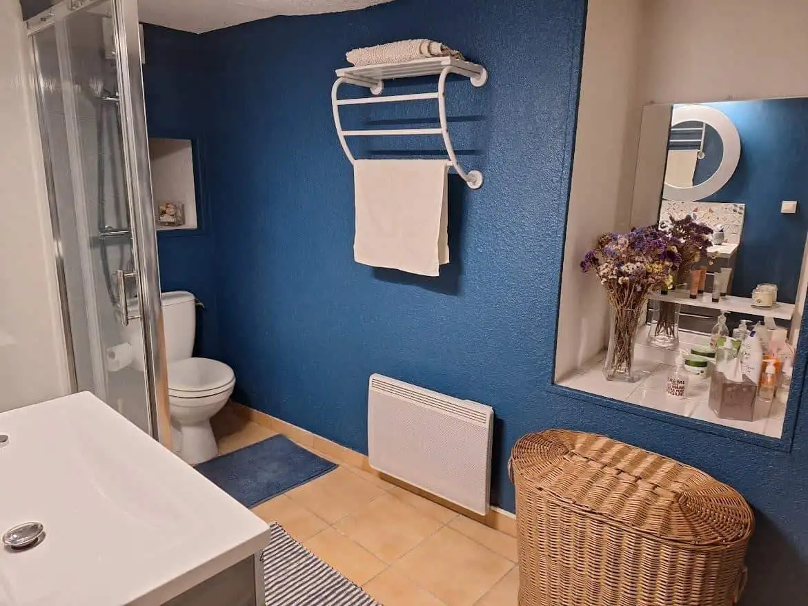 Cozy Bathroom in Ria-Sirach Village House Bright bathroom with modern fixtures and a blue accent wall in a renovated village home.