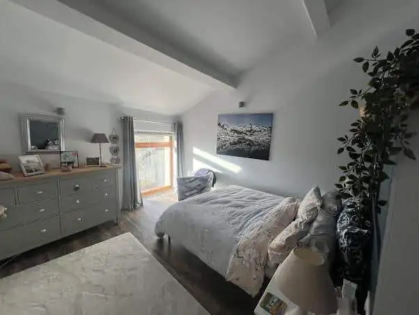Bright bedroom featuring a large window with scenic mountain vistas in Ria-Sirach, France.
