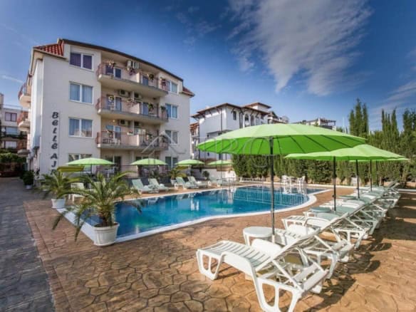Bright poolside view at Belle Air Complex with sun loungers and umbrellas.