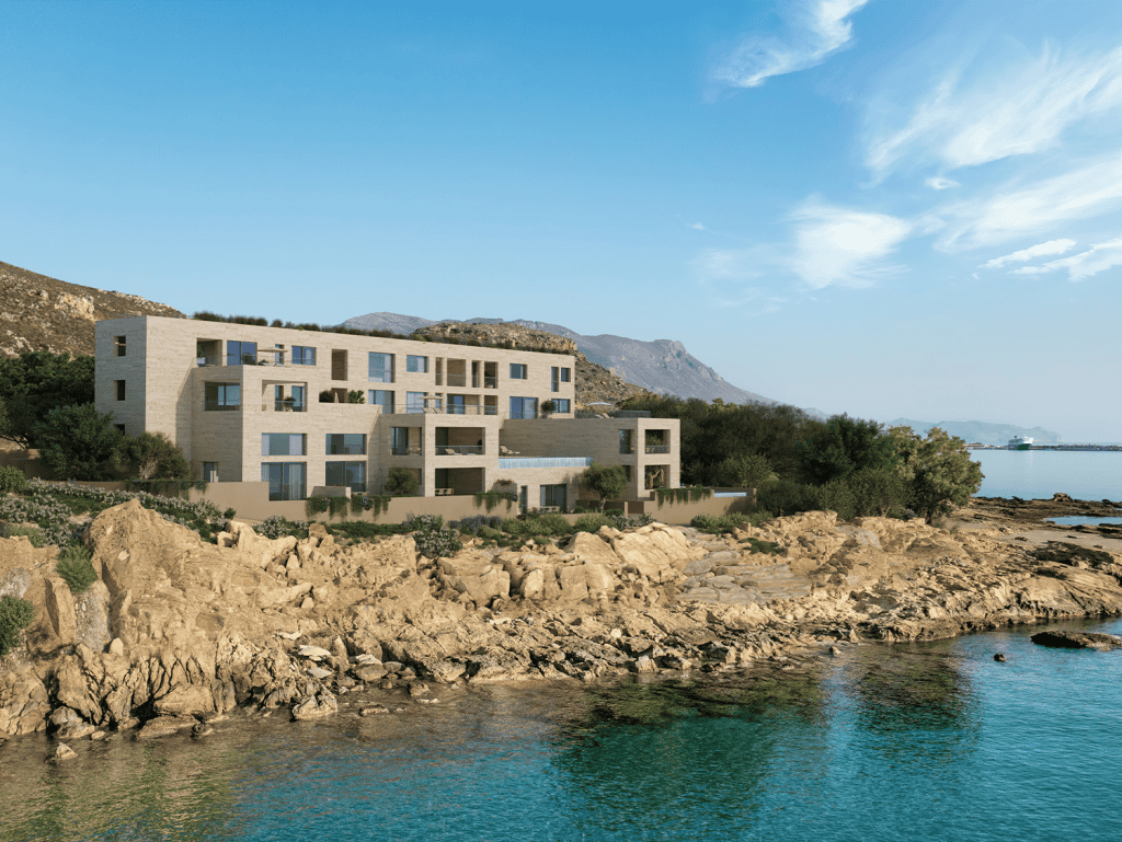Modern waterfront apartment building in Kissamos, Crete, overlooking the sea with scenic mountain vi.