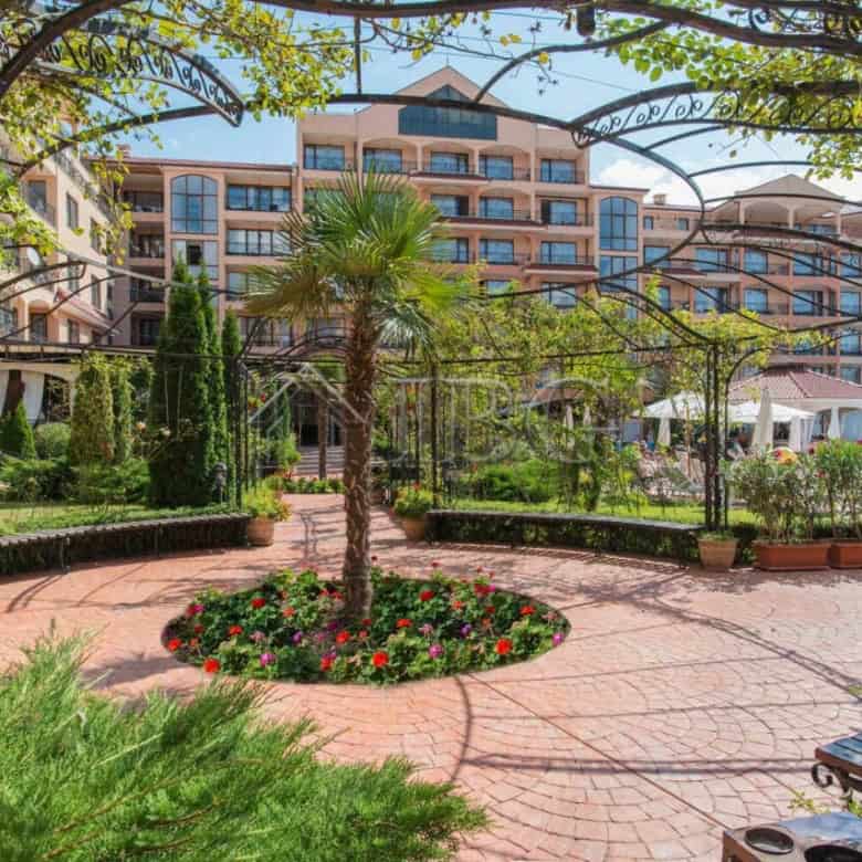 Furnished studio apartment with balcony in Diamant Residence, Sunny Beach, surrounded by lush garden.