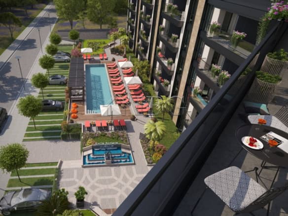 Modern residential complex with pool, sun loungers, and outdoor seating area.