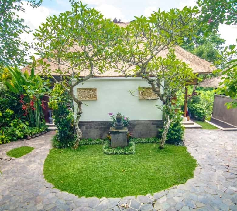 Ubud Bali garden villa with lush greenery and stone pathways.