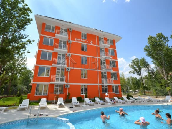 Bright orange apartment building at Gerber 4 Sunny Beach with pool view.