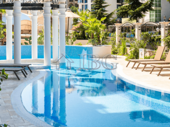 Modern swimming pool with sun loungers and lush greenery at Harmony Dream Park, Sunny Beach.