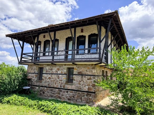 Two-storey traditional Bulgarian house with stone foundation and wooden balcony in Bata village, Bur.