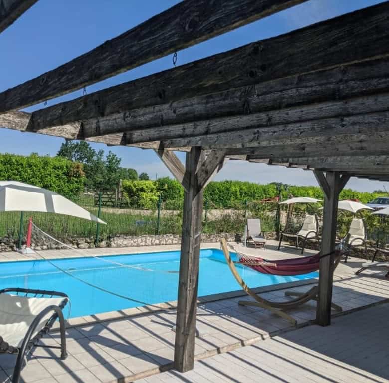 Beautiful outdoor pool area at a luxury equestrian property in Chatignac, France, featuring shaded l.