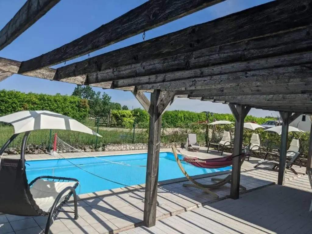 Beautiful outdoor pool area at a luxury equestrian property in Chatignac, France, featuring shaded l.