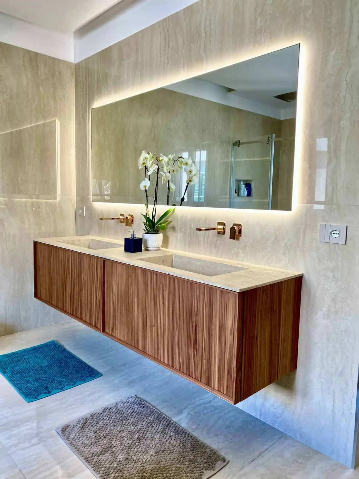 Modern bathroom with wooden vanity and large mirror.
