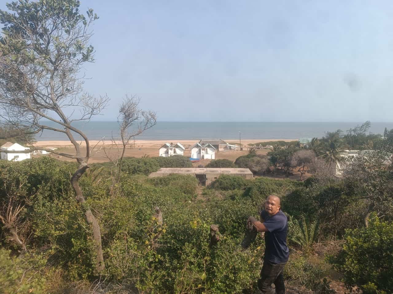 Beachside property with lush greenery and a man enjoying the view. Beachside property with lush greenery and a man enjoying the view.