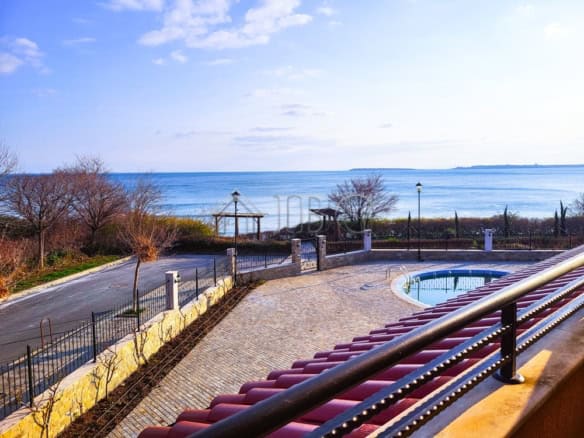 Balcony overlooking the sea with a view of the coastline and calm waters.