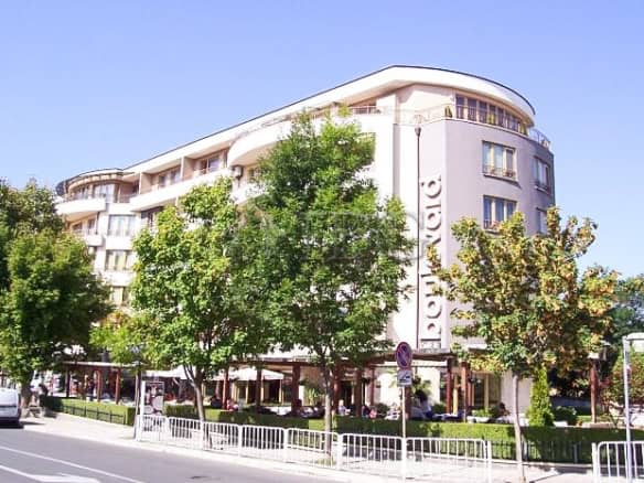 Balcony with 2 chairs and table, overlooking lush greenery in a central Nessebar residence.
