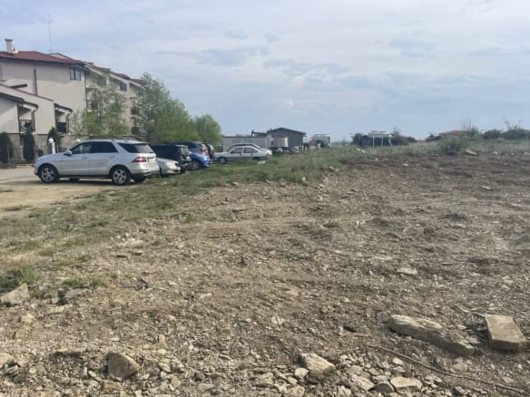 Empty plot of land in a residential neighborhood, suitable for building homes or investment.