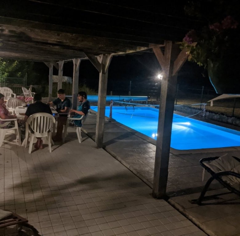 Elegant outdoor pool area at night with seating for guests.