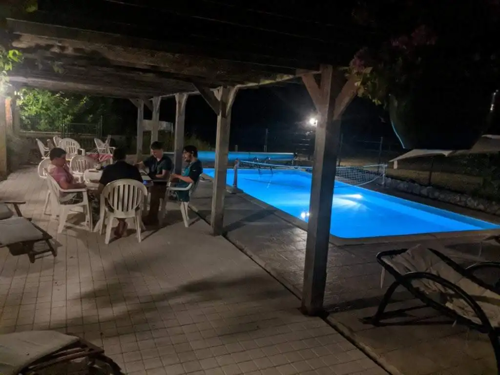 Elegant outdoor pool area at night with seating for guests.